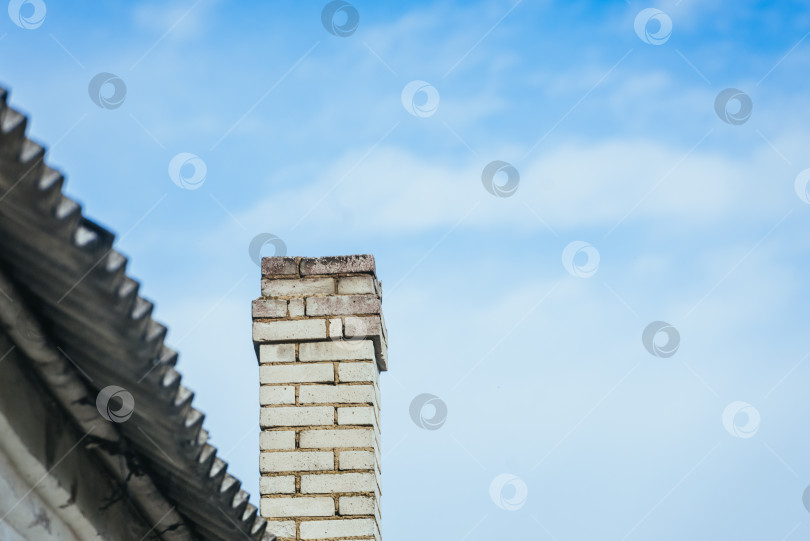 Скачать Дымоход на крыше дома на фоне голубого неба фотосток Ozero
