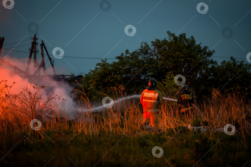 Скачать Горение каменного дома, пожар и концепция чрезвычайных ситуаций - пожарные тушат дом фотосток Ozero