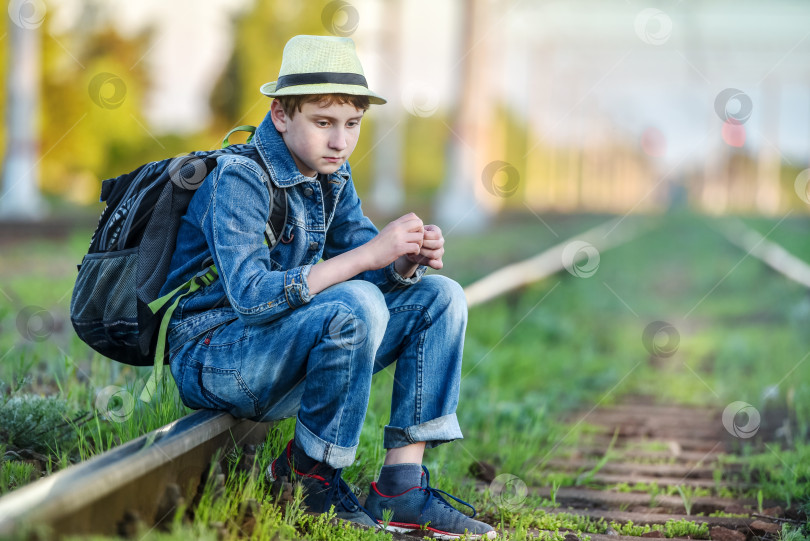 Скачать грустный парень сидит вечером на железной дороге фотосток Ozero