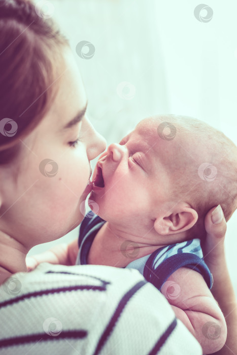 Скачать Молодая мать целует новорожденного ребенка фотосток Ozero