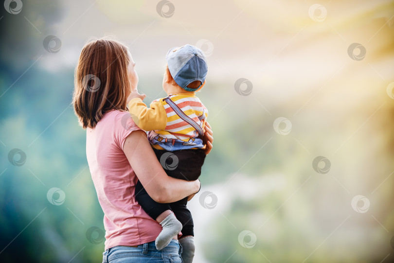 Скачать мама держит малыша на руках на фоне природы фотосток Ozero