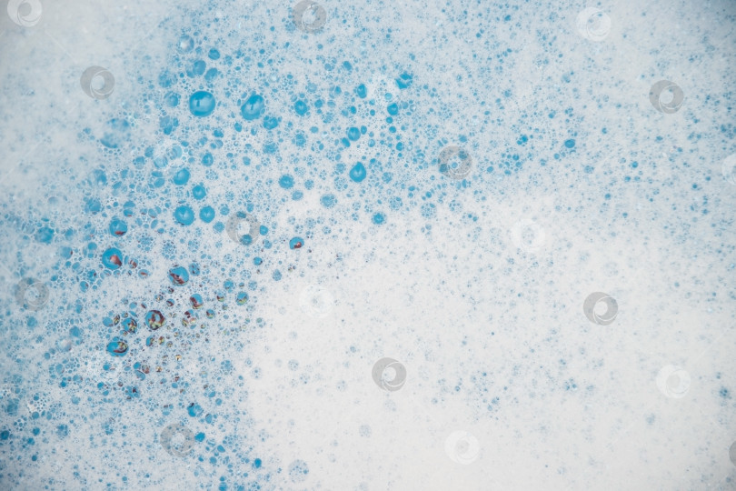 Скачать Абстрактная фоновая текстура белой мыльной пены. Пена для шампуня с пузырьками на синем фоне. фотосток Ozero