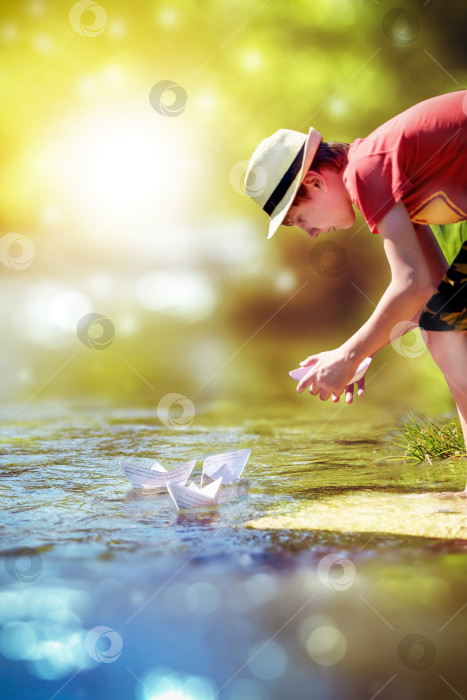 Скачать мальчик запускает бумажные кораблики по реке фотосток Ozero