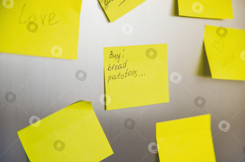 Скачать Желтые квадратные наклейки приклеены к холодильнику.Напоминания, список покупок. Пустое место для текста. фотосток Ozero