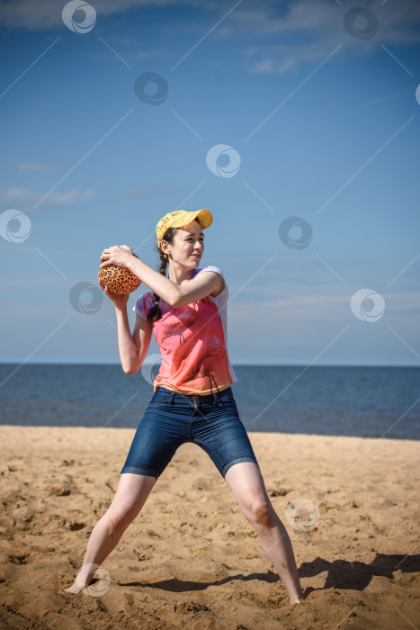 Скачать Счастливая девушка на пляже играет в мяч фотосток Ozero
