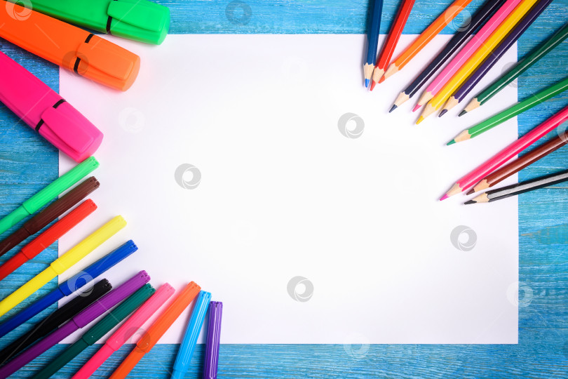 Скачать Рамка из цветных карандашей вокруг белого листа на деревянном фоне фотосток Ozero