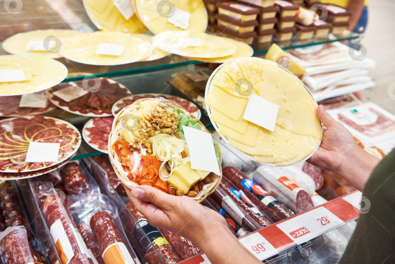 Скачать Нарезанный сыр и колбаса в руках в магазине фотосток Ozero