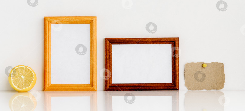 Скачать Две деревянные рамки с белой вставкой внутри, лимон и кусочек крафт-бумаги. фотосток Ozero
