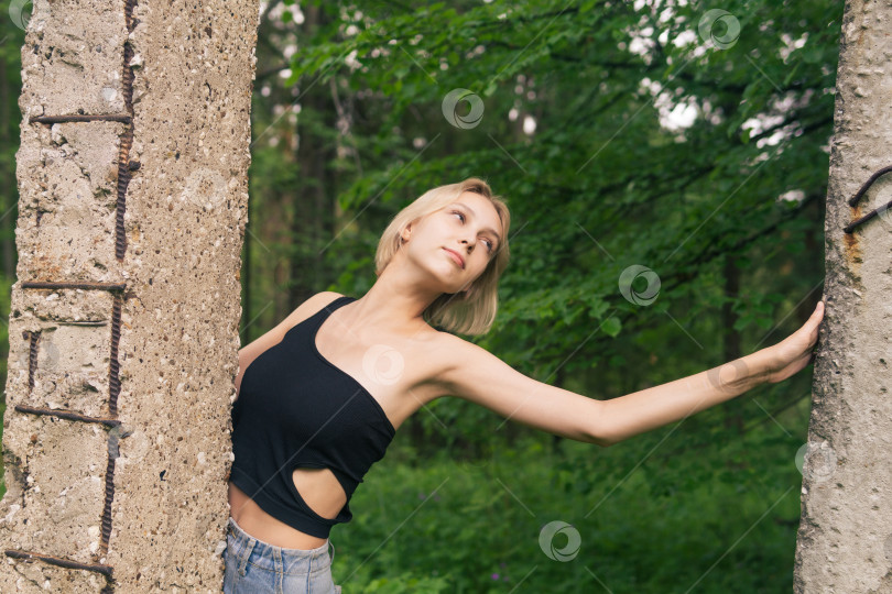 Скачать молодая женщина позирует рядом с бетонными сваями среди природного ландшафта фотосток Ozero