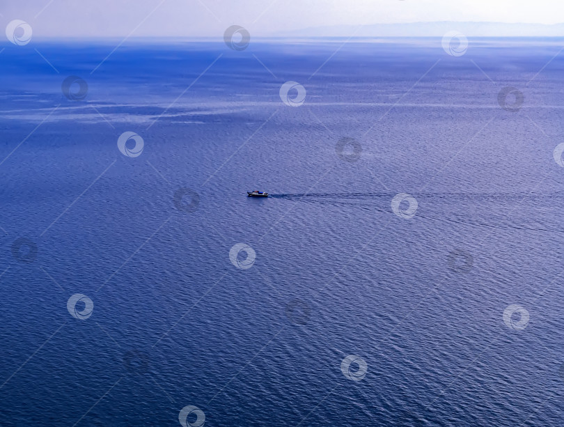 Скачать Вид на горизонт с маленьким кораблем над большим водоемом. Солнечный летний день, панорамный голубой водный пейзаж. фотосток Ozero