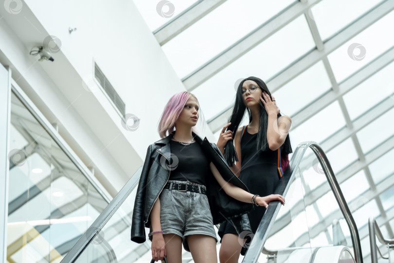 Скачать две девочки-подростка на эскалаторе в торговом центре фотосток Ozero