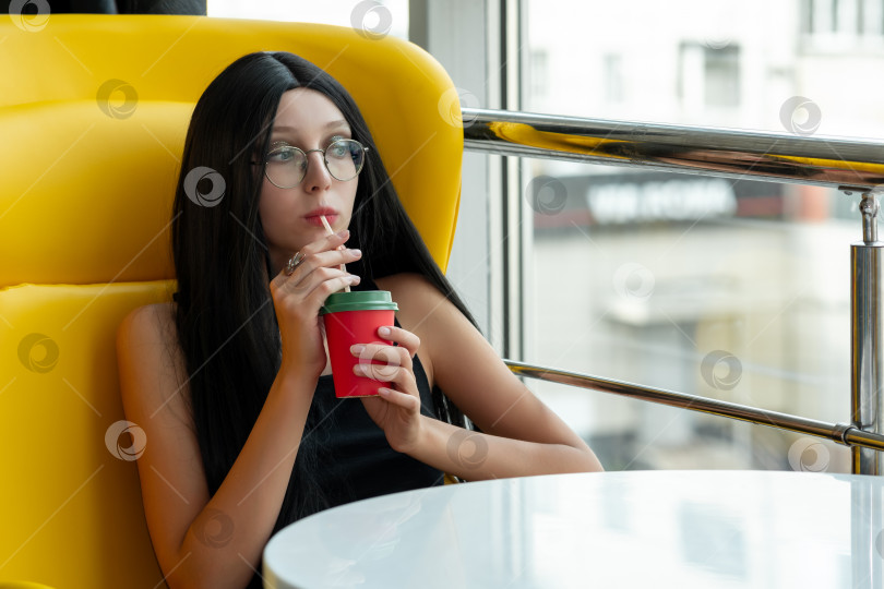 Скачать девочка-подросток пьет коктейль в кафетерии, думая о чем-то фотосток Ozero