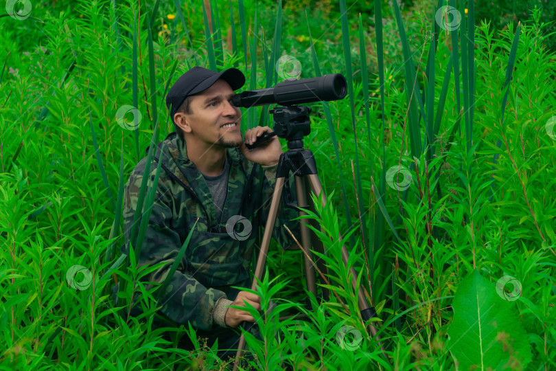 Скачать человек-орнитолог ведет полевые наблюдения с помощью зрительной трубы фотосток Ozero