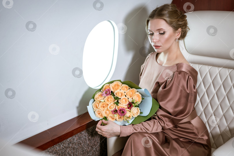 Скачать счастливая стильная женщина сидит в частном самолете у иллюминатора фотосток Ozero