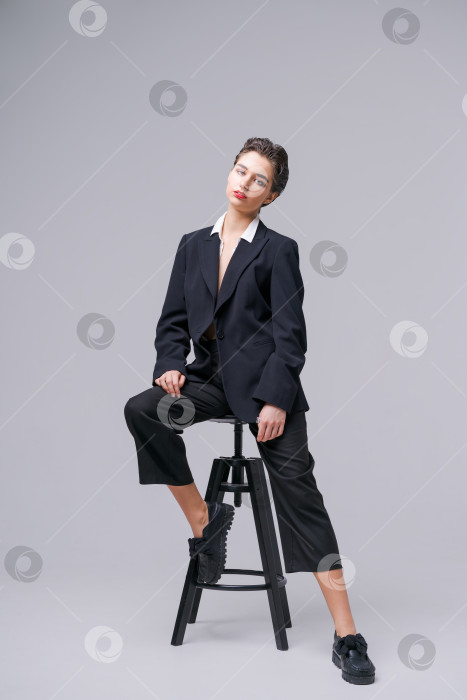 Скачать Красивая молодая бизнесвумен в модном черном костюме и белой рубашке позирует фотосток Ozero