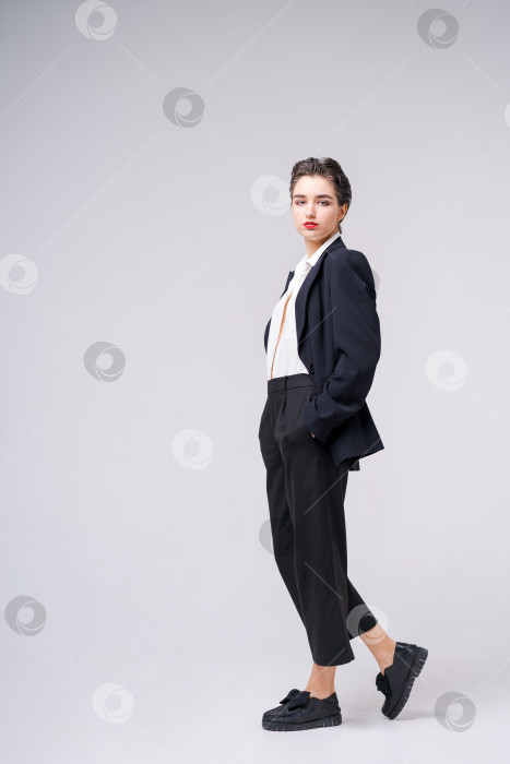 Скачать Привлекательная деловая молодая женщина позирует в деловом черном костюме с короткими фотосток Ozero