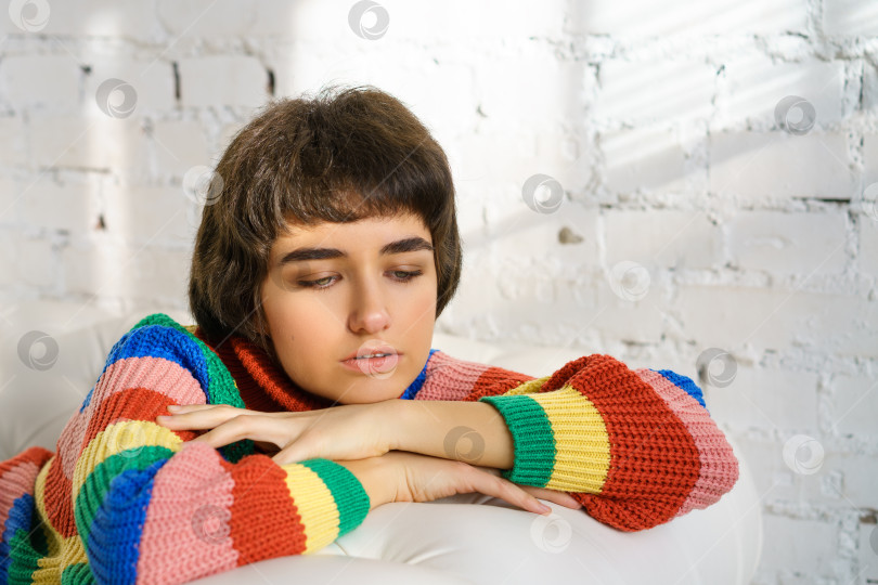 Скачать Портрет молодой женщины в разноцветном свитере, грустной фотосток Ozero