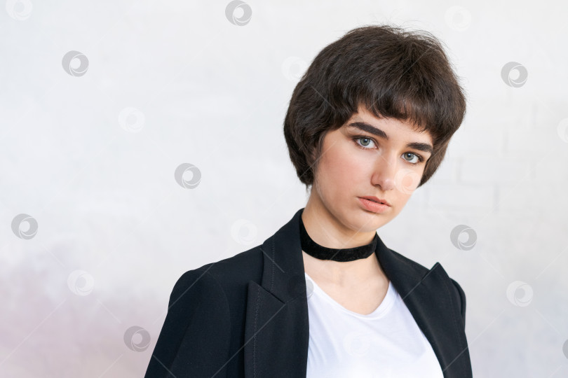 Скачать Портрет девушки в черной куртке с шашкой на шее на фоне стены. Хорошенький фотосток Ozero