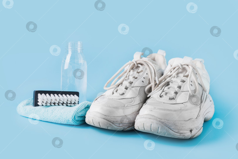 Скачать Грязные белые кроссовки со специальным средством для их чистки на синем. фотосток Ozero