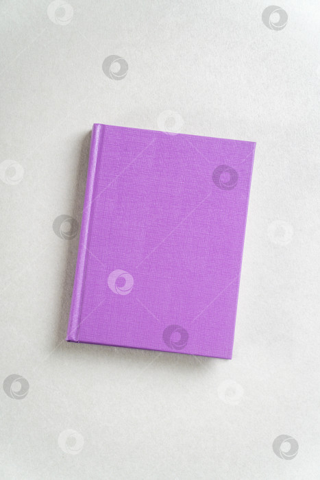 Скачать Фиолетовый закрытый блокнот на сером фоне, вид сверху фотосток Ozero