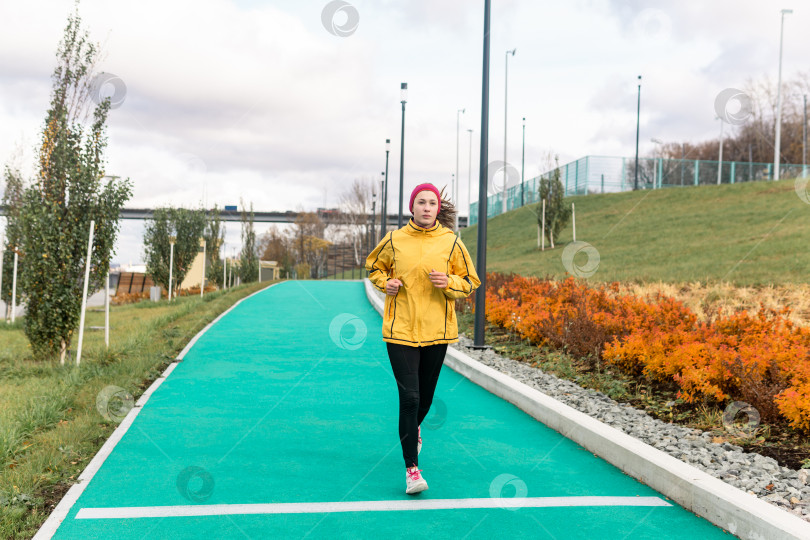 Скачать молодая женщина бегает трусцой по парку фотосток Ozero