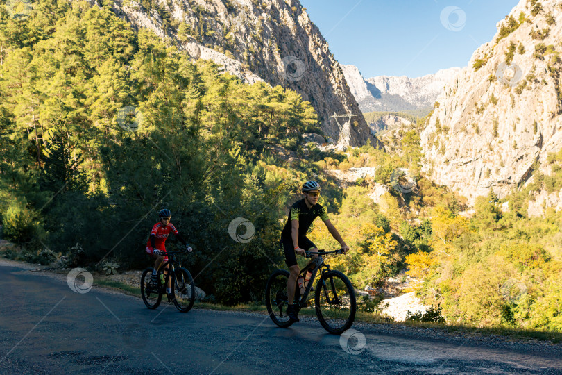 Скачать мужчина и женщина-велосипедисты едут по горной дороге в горах Таурус, Турция фотосток Ozero