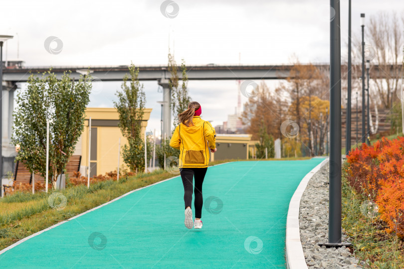 Скачать молодая женщина бегает трусцой в парке вдоль набережной фотосток Ozero