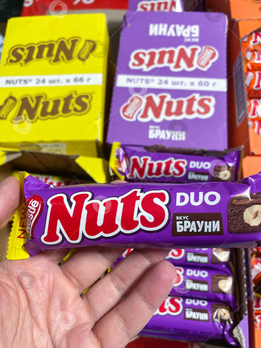 Скачать Тюмень, Россия - 20 августа 2022 года: Шоколадная плитка Nuts duo candy производства Nestle в ручную. Избирательный фокус фотосток Ozero