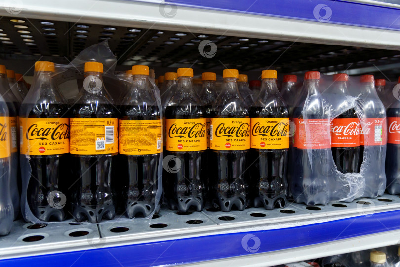Скачать Тюмень, Россия - 25 марта 2022 года: Различные пластиковые бутылки Coca-Cola продаются в магазинах, ресторанах по всему миру. фотосток Ozero