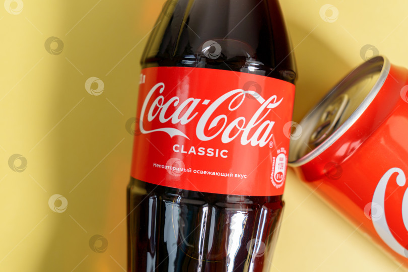 Скачать Тюмень, Россия - 03 апреля 2022 года: Продукция Coca-Cola Company, американской многонациональной корпорации по производству напитков. Желтый фон фотосток Ozero