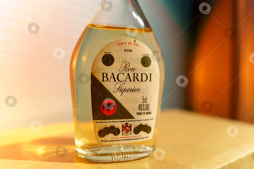 Скачать Тюмень, Россия - 30 марта 2022 года: Бокал с логотипом Bacardi Superior rum, крупнейшей частной семейной компании по производству спиртных напитков в мире. Избирательный фокус фотосток Ozero