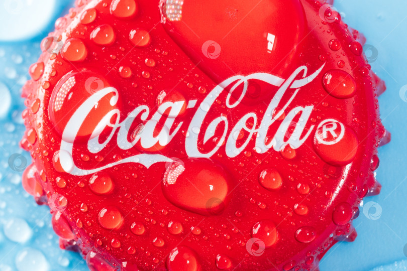 Скачать Тюмень, Россия - 19 января 2022 года: Крышка Coca-Cola classic крупным планом в воде. Coca-cola - самый продаваемый в мире газированный безалкогольный напиток фотосток Ozero