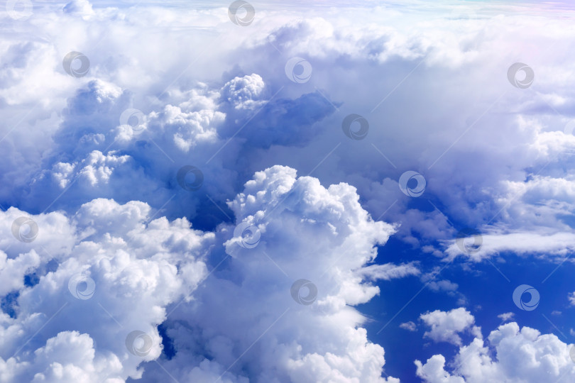Скачать Белые пушистые облака внизу. Выгляните из иллюминатора самолета в солнечную погоду с высоты птичьего полета. Фон фотосток Ozero