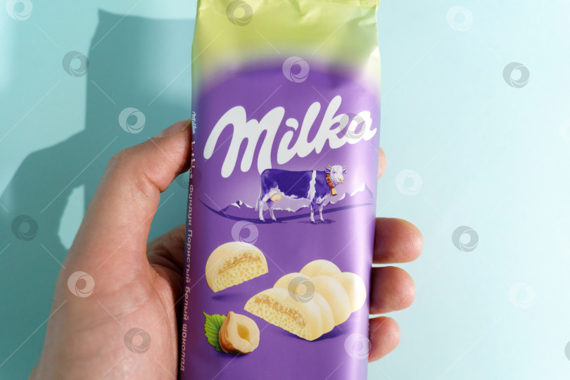 Скачать Тюмень, Россия- 03 марта 2022 г.: Milka white chocolate and hazelnuts - швейцарский бренд шоколадных кондитерских изделий, производимых международной компанией Mondelez International фотосток Ozero