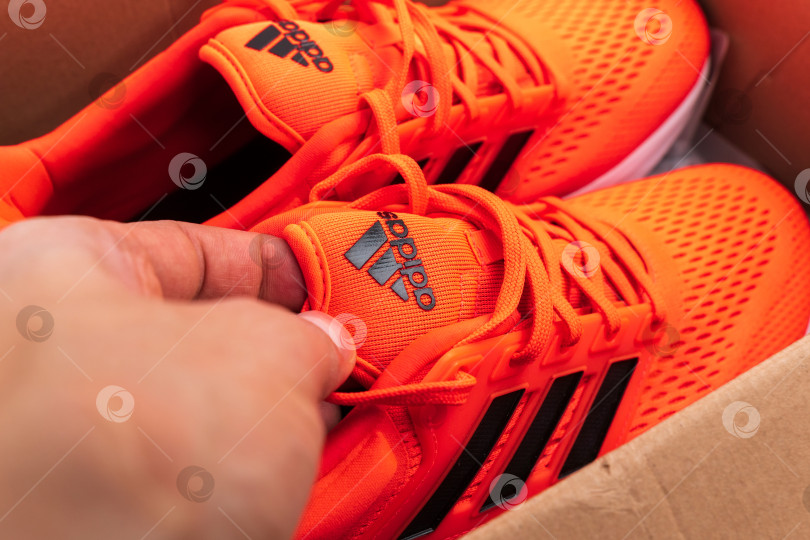 Скачать Тюмень, Россия - 13 ноября 2021 года: логотип Adidas на оранжевых кроссовках крупным планом. Избирательный фокус фотосток Ozero
