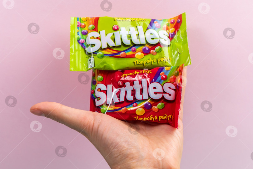 Скачать Тюмень, Россия - 27 декабря 2021 года: Оригинальные конфеты марки Skittles. Разноцветный фон. вкусные сладкие кегли фотосток Ozero