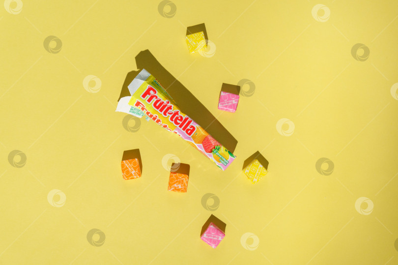 Скачать Тюмень, Россия- 03 апреля 2022 года: Жевательная резинка Fruittella и конфеты на желтом фоне фотосток Ozero
