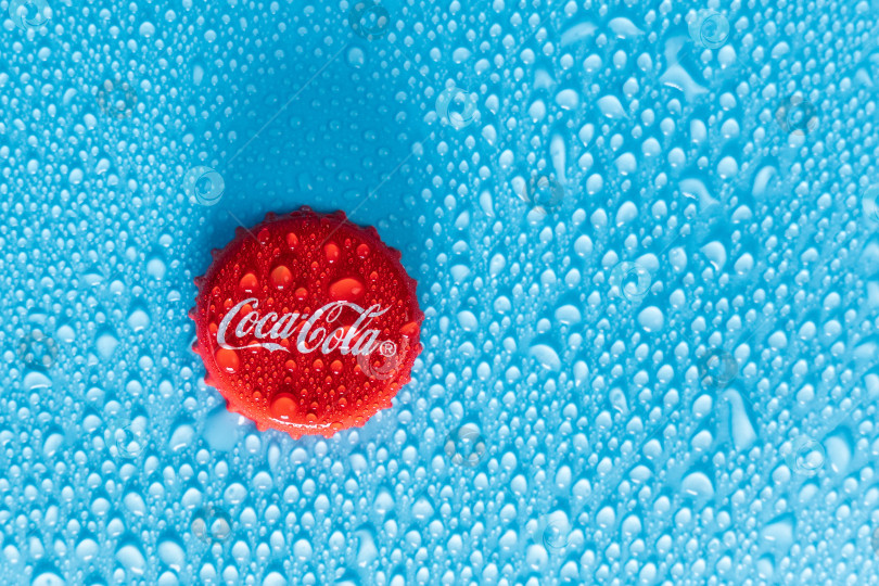 Скачать Тюмень, Россия - 19 января 2022 года: Красная крышка стеклянной бутылки Coca-Cola. Капли воды копируют пространство фотосток Ozero