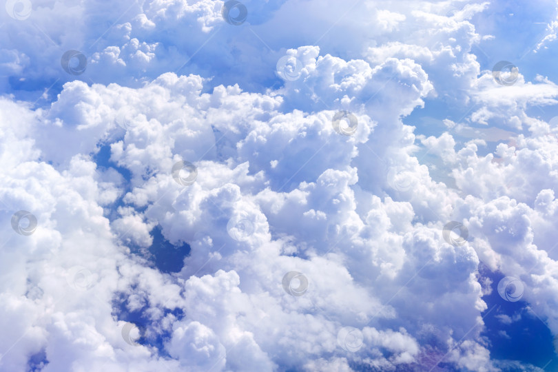 Скачать Белые пушистые облака внизу. Вид сверху из иллюминатора самолета, летящего в облаках. Избирательный фокус фотосток Ozero