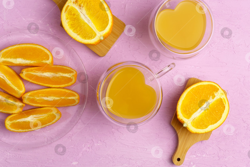 Скачать Свежевыжатый апельсиновый сок в стакане и апельсины на розовом фоне. Вид сверху. фотосток Ozero