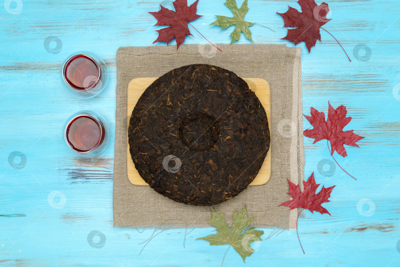 Скачать Черный чай пуэр, сухие листья чая пуэр на синем фоне, чайная церемония. Плоская поверхность фотосток Ozero
