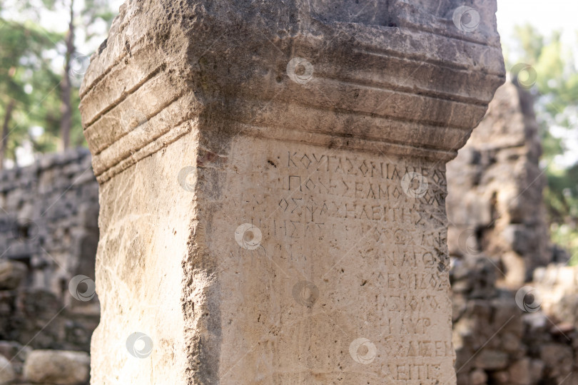 Скачать полустертая античная надпись на камне среди руин древнего города Фазелис, Турция фотосток Ozero