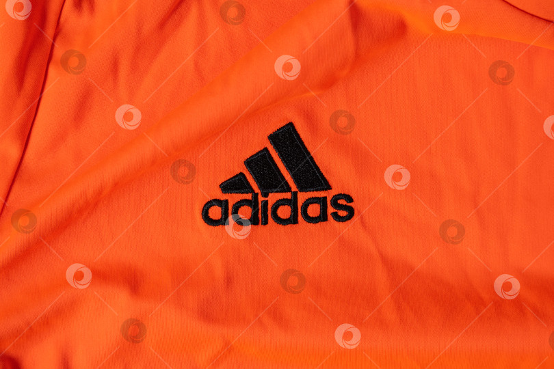 Скачать Тюмень, Россия - 11 мая 2022 года: Логотип Adidas крупным планом. Adidas - всемирно известный спортивный бренд. фотосток Ozero