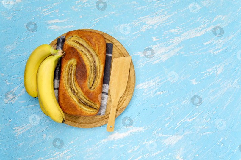 Скачать Испеченный банановый хлеб. пекарня, кафе, домашний шеф-повар, концепции меню. Вид сверху на синем фоне. Пространство для копирования фотосток Ozero