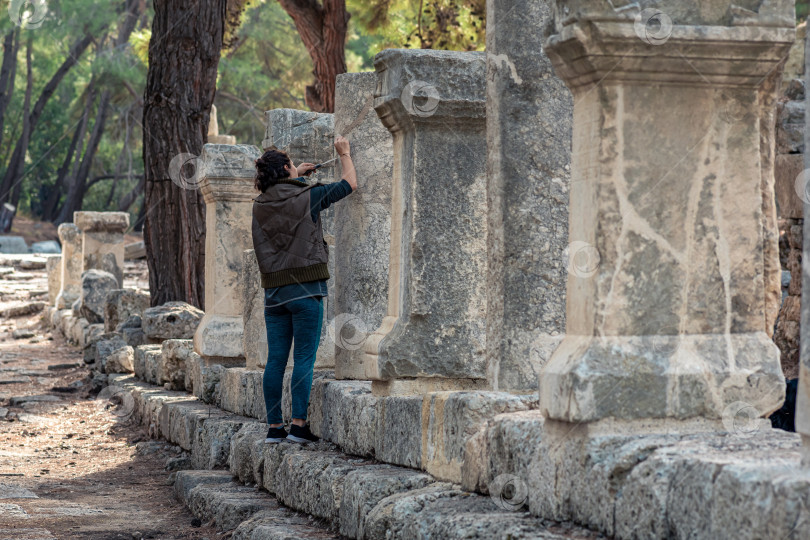 Скачать археолог восстанавливает древнюю надпись на колонне в Фазелисе, Турция фотосток Ozero