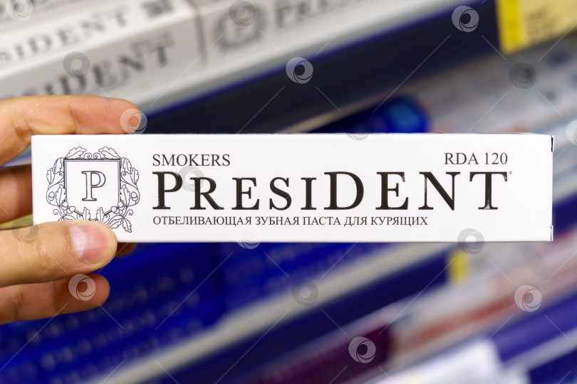 Скачать Тюмень, Россия - 27 мая 2022 года: Зубная паста President smokers в руках покупателя, распродажа товаров в гипермаркете. Избирательный фокус фотосток Ozero