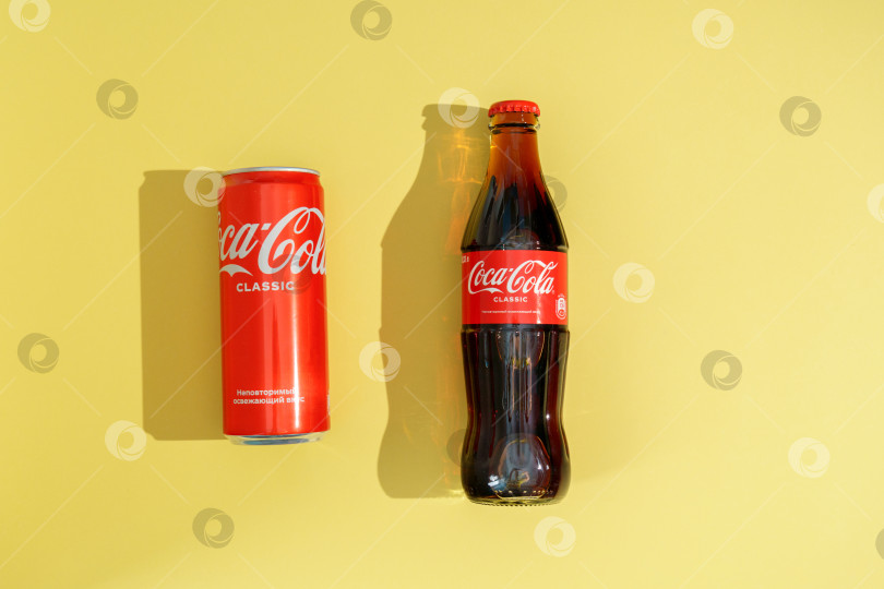 Скачать Тюмень, Россия - 03 апреля 2022 года: Классические напитки Coca-Cola в банках и бутылках. Компания является ведущим производителем газированных напитков в мире. фотосток Ozero