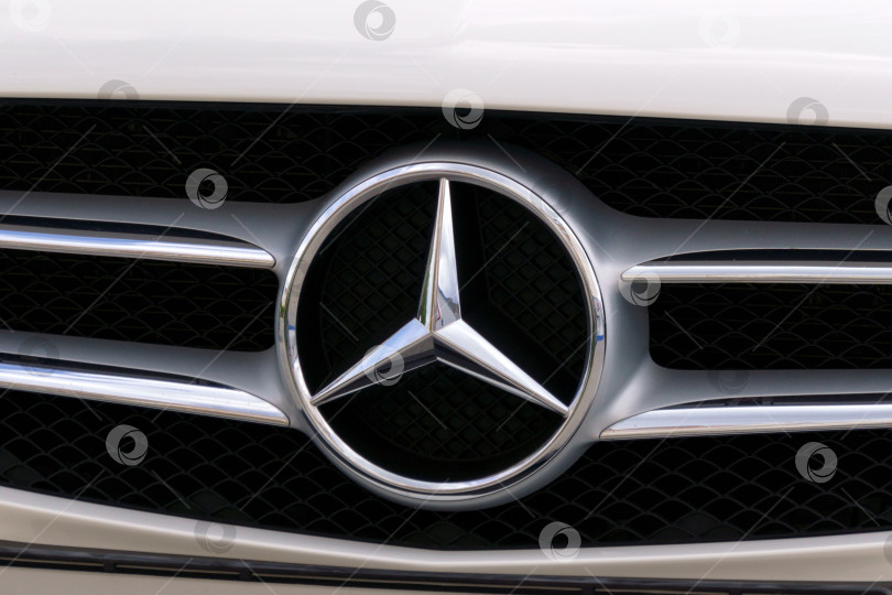 Скачать Тюмень, Россия - 06 июня 2022 года: Логотип Mercedes Benz крупным планом на автомобиле. Бренд используется для автомобилей класса люкс, автобусов междугородних и грузовых перевозок. Избирательный фокус фотосток Ozero