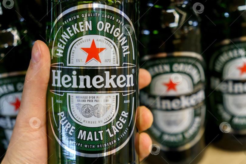 Скачать Тюмень, Россия - 08 мая 2022 года: Бутылки Heineken в гипермаркете International, которому принадлежит более 125 пивоварен в более чем 70 странах. фотосток Ozero