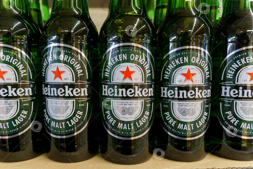 Скачать Тюмень, Россия - 08 мая 2022 года: Бутылки Heineken в гипермаркете International, которому принадлежит более 125 пивоварен в более чем 70 странах. фотосток Ozero